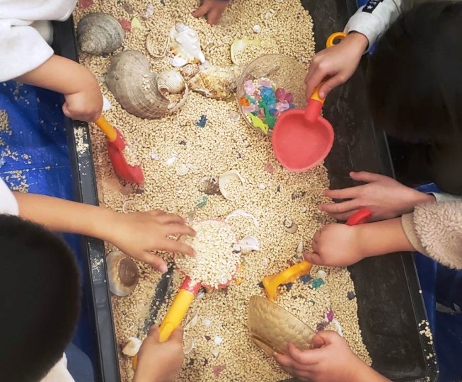 砂に埋まった宝物を探す子供たち
